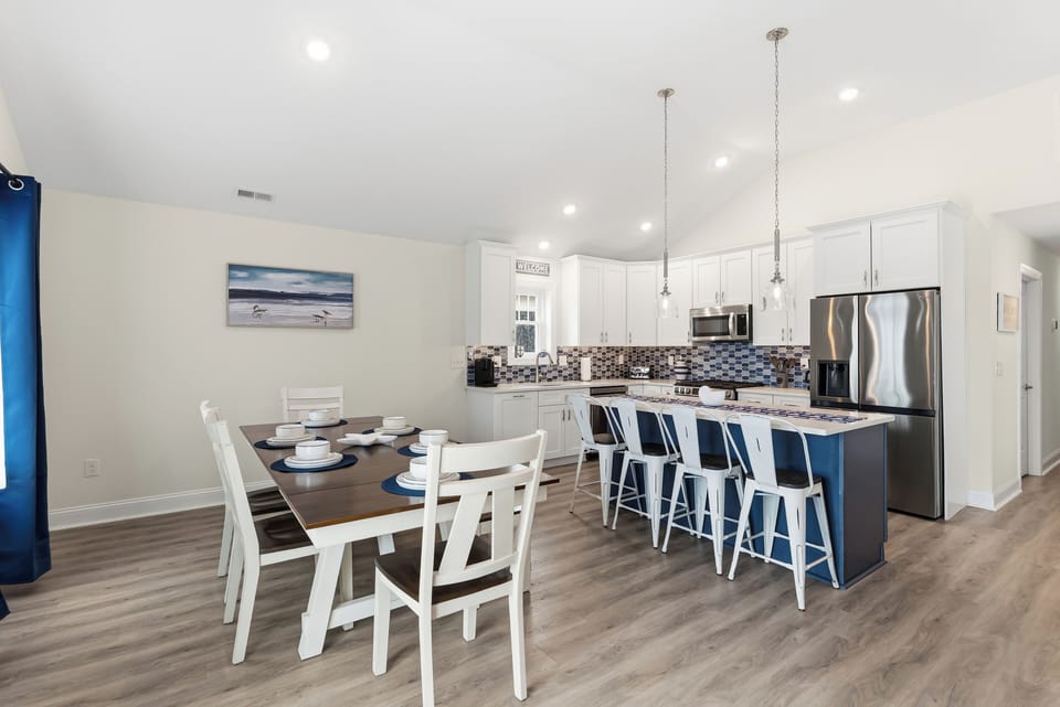 Bright open kitchen with large island, bar seating, and dining for the group