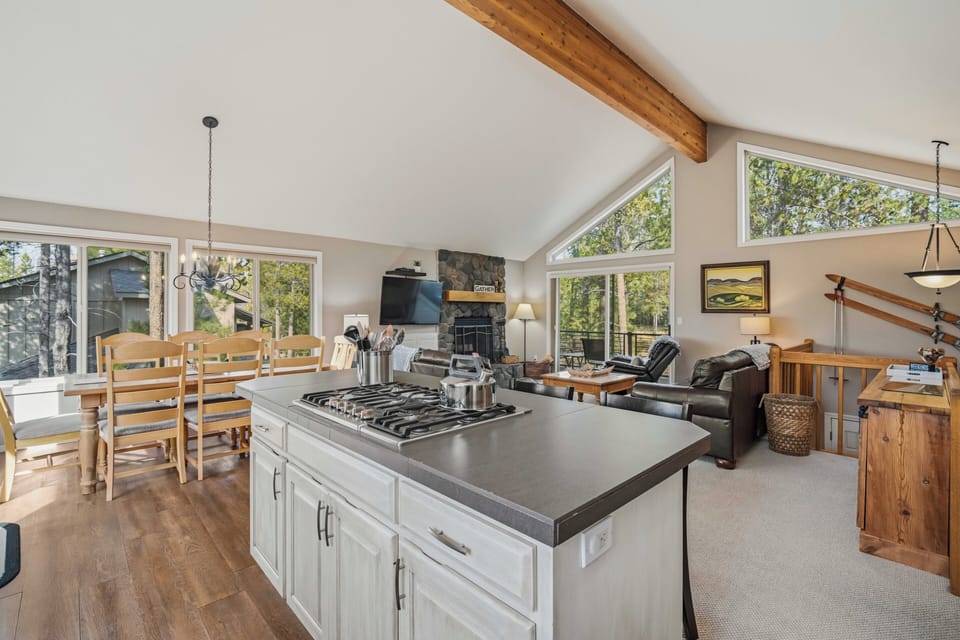 Spacious open-concept living with your fully equipped kitchen island, cozy fireplace seating, and abundant natural light streaming through large windows.