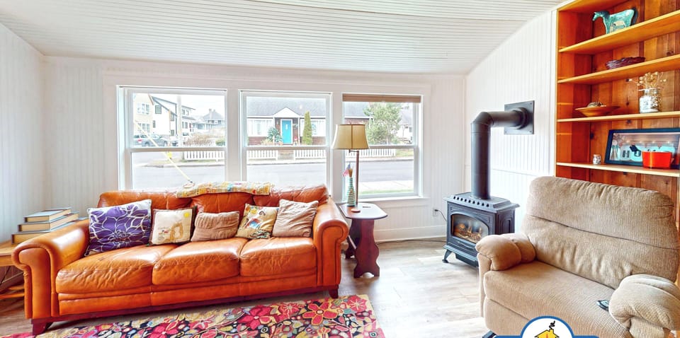 Sink into comfortable leather seating by your cozy wood-burning stove, with beautiful built-in shelves showcasing coastal treasures.