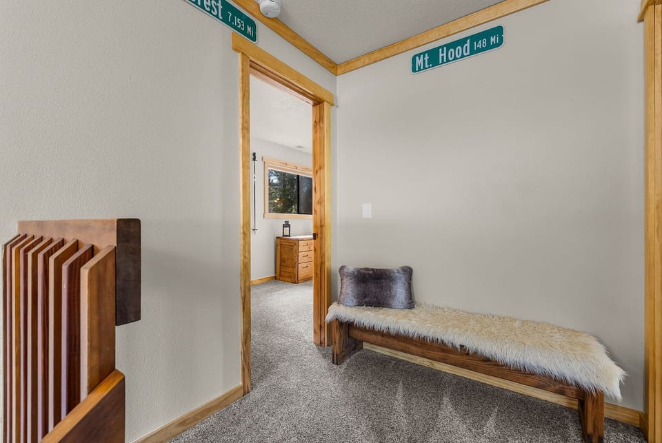 Your cozy mountain retreat hallway features warm wood accents and charming street signs, creating a welcoming cabin atmosphere.