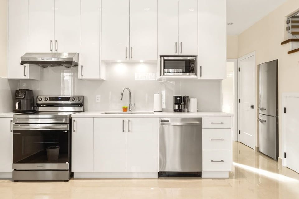 Kitchen with coffee machine, kettle, and basic cooking essentials.