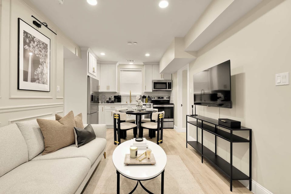 The open layout means the cook stays part of the conversation — one continuous flow from kitchen through dining to living, so no one gets left out.