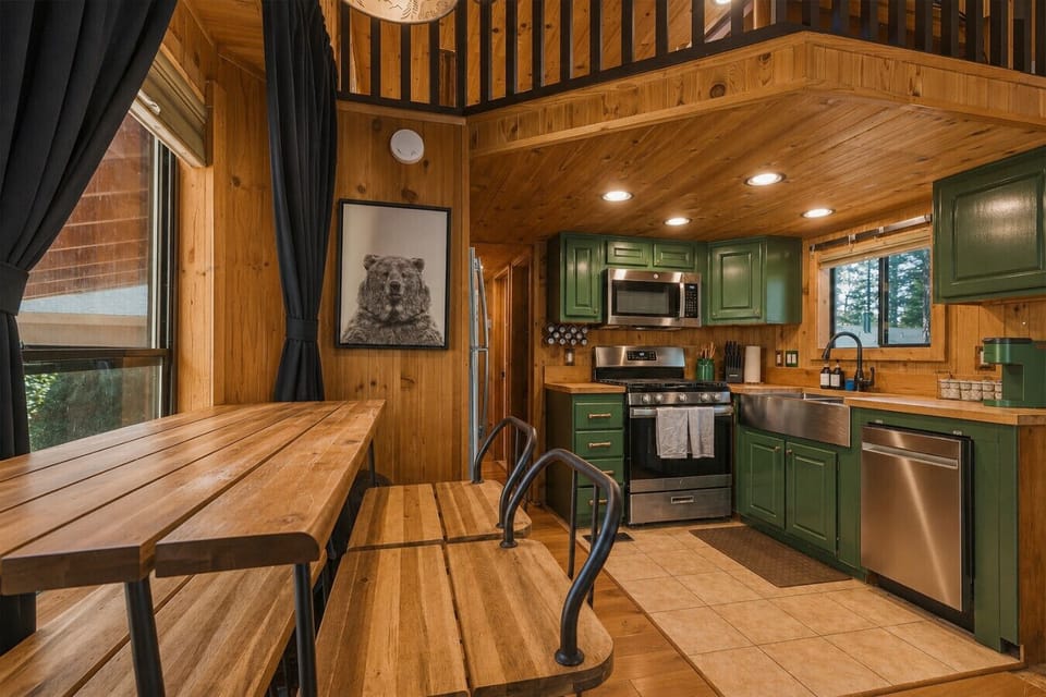 Gather around the rustic dining space or cook with ease in the fully equipped kitchen featuring modern appliances and charming cabin details. The open layout makes it perfect for shared meals and quality time together.