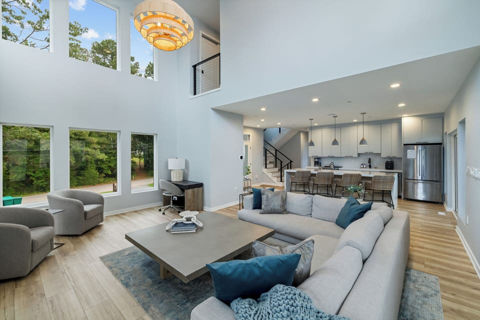 The two-story living room, framed by expansive windows overlooking the Bay and the lake.