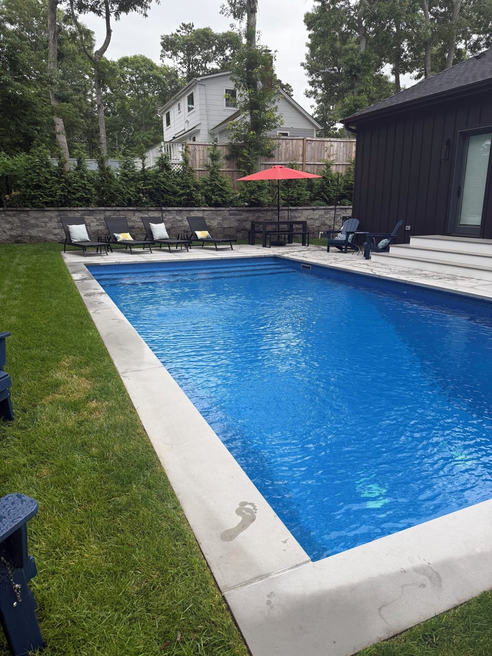 Private salt water pool with sun chairs and dining table 