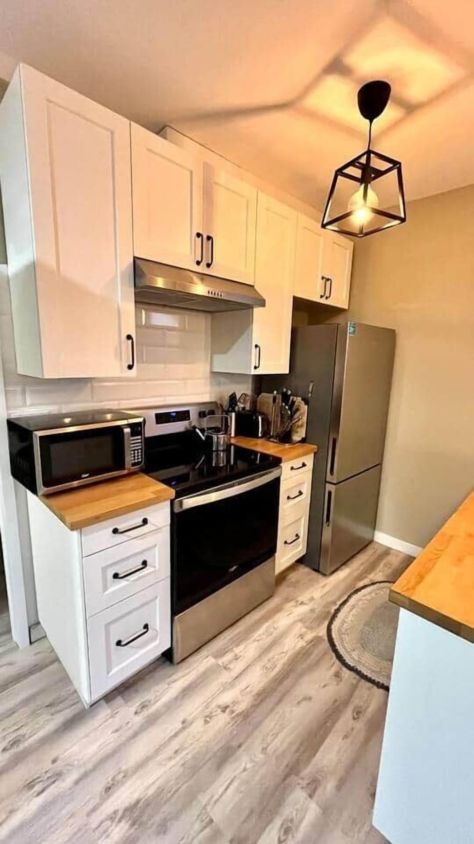 Modern, well-equipped kitchen with stainless appliances & butcher block counters