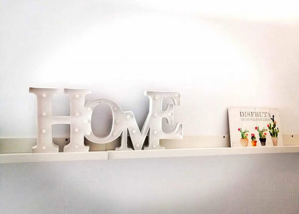 A decorative sign and plaque on the shelf in the entryway.