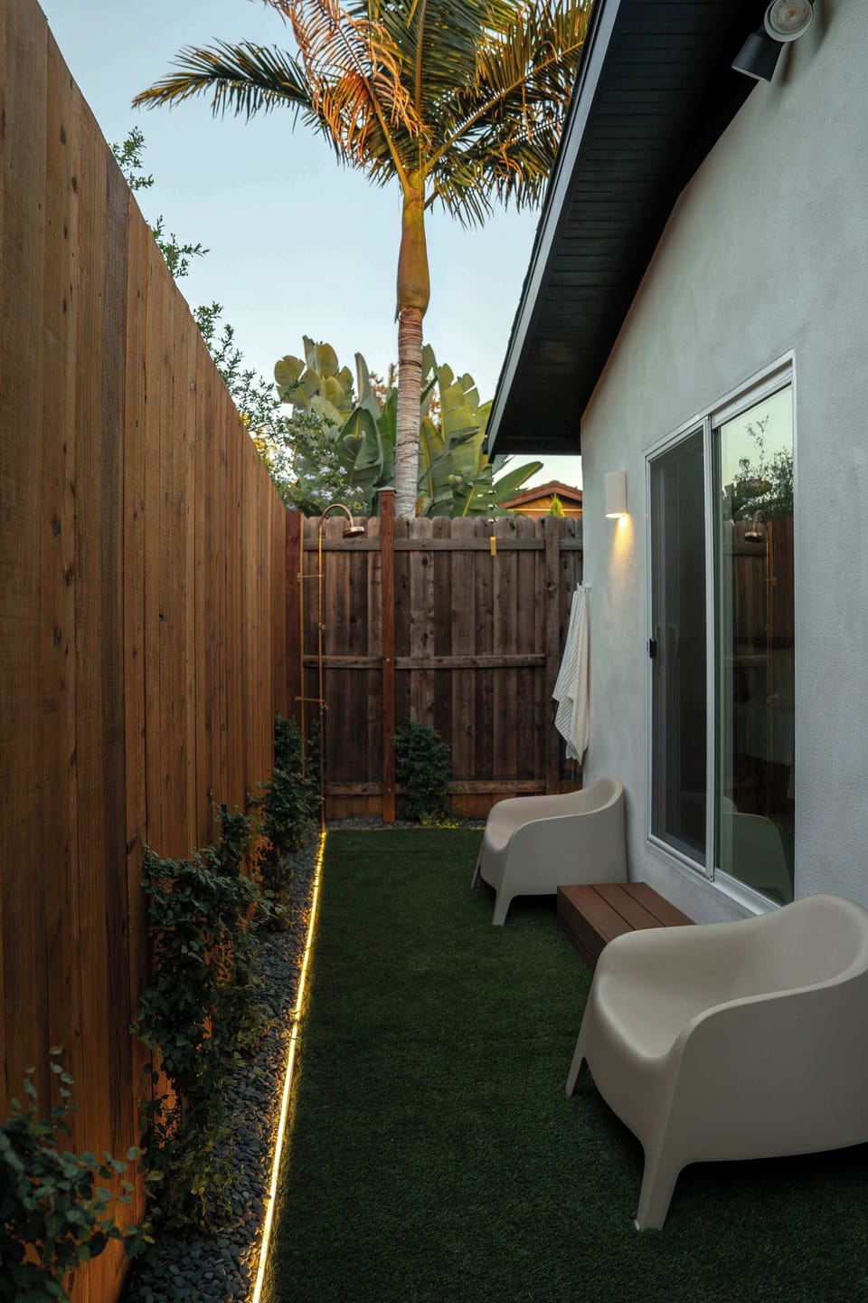 A tucked-away garden with warm lighting and a palm tree that sets the scene.