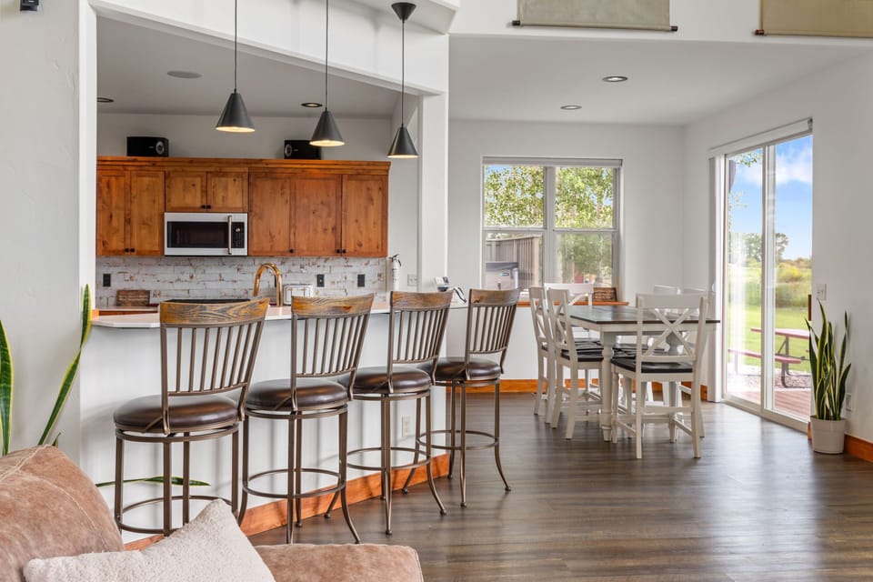 Bright open kitchen and dining area with breakfast bar and patio views