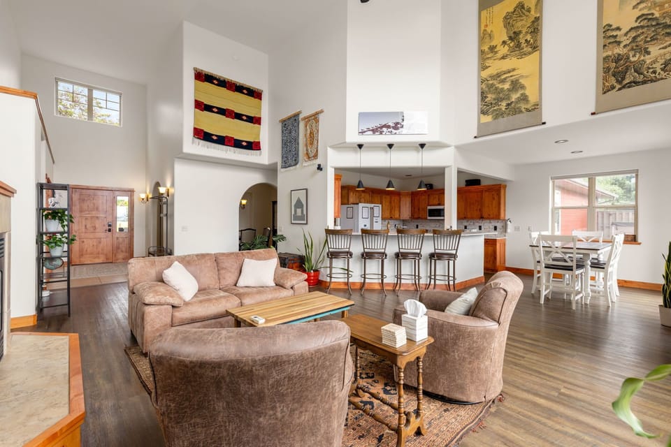 Bright open-concept living area with high ceilings, bar seating, and dining space