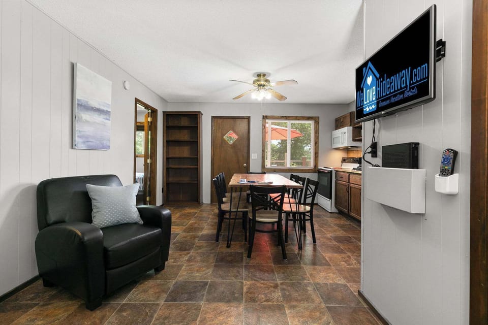 Open floor plan with living room, leather seating, TV, and kitchen