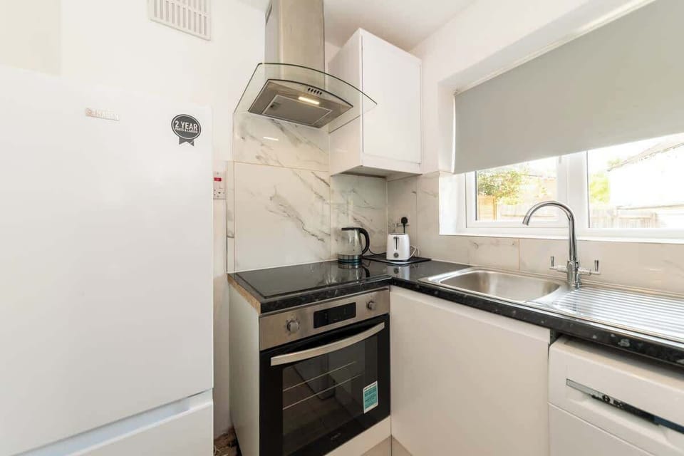 Kitchen detail showing appliances and counter space. Washer for work clothes, oven for proper meals. All bills included.