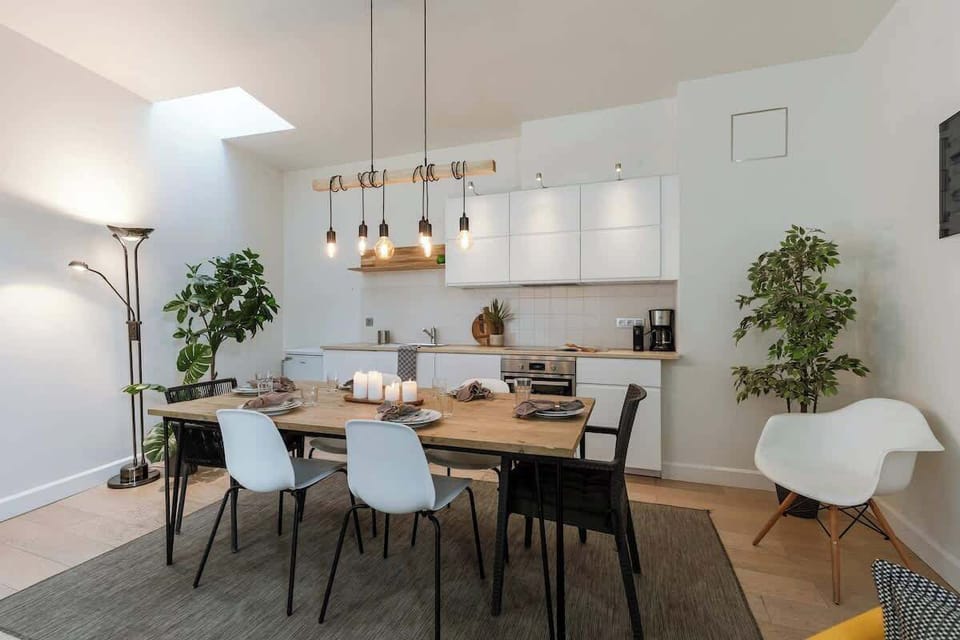 Dining corner with modern lights and lush green touches.

