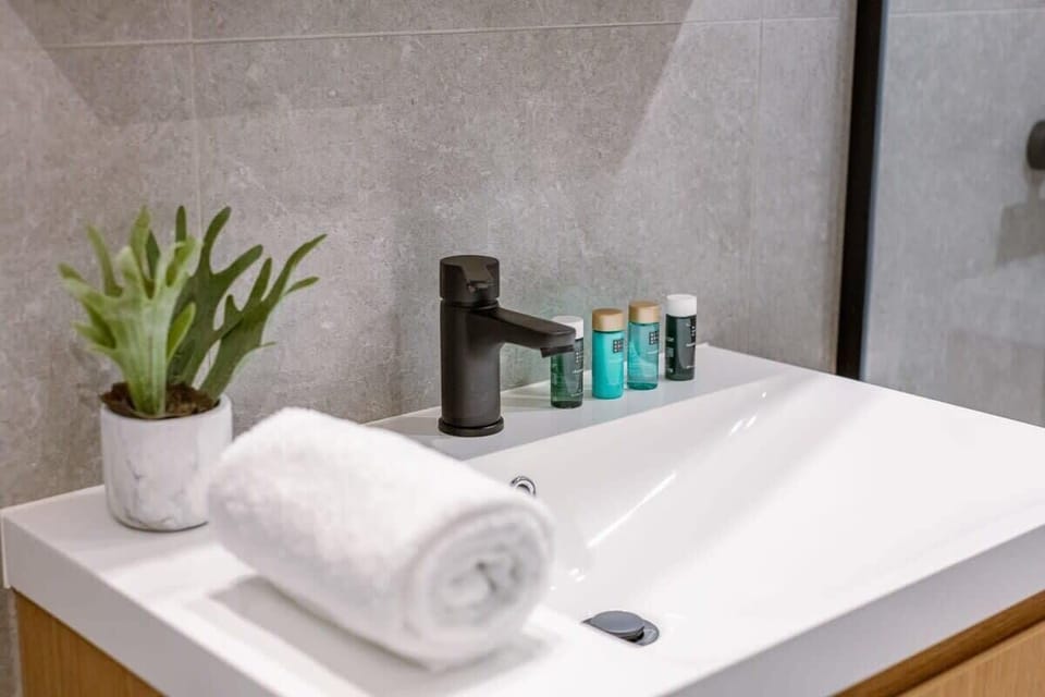 Modern bathroom sink with black faucet and complimentary toiletries