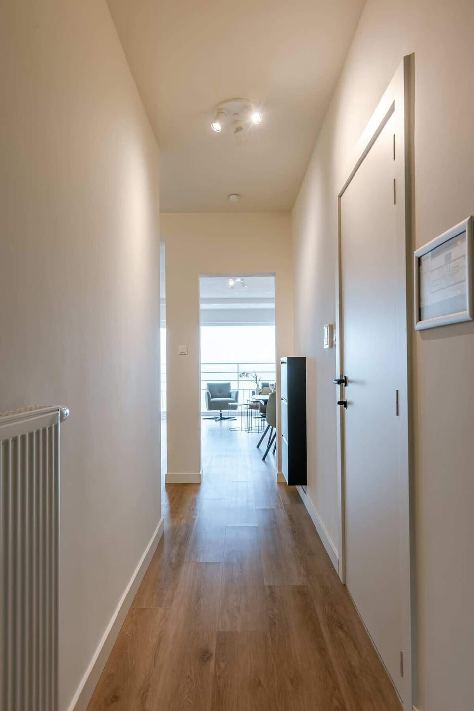 Bright hallway leading to open living space and ocean light.