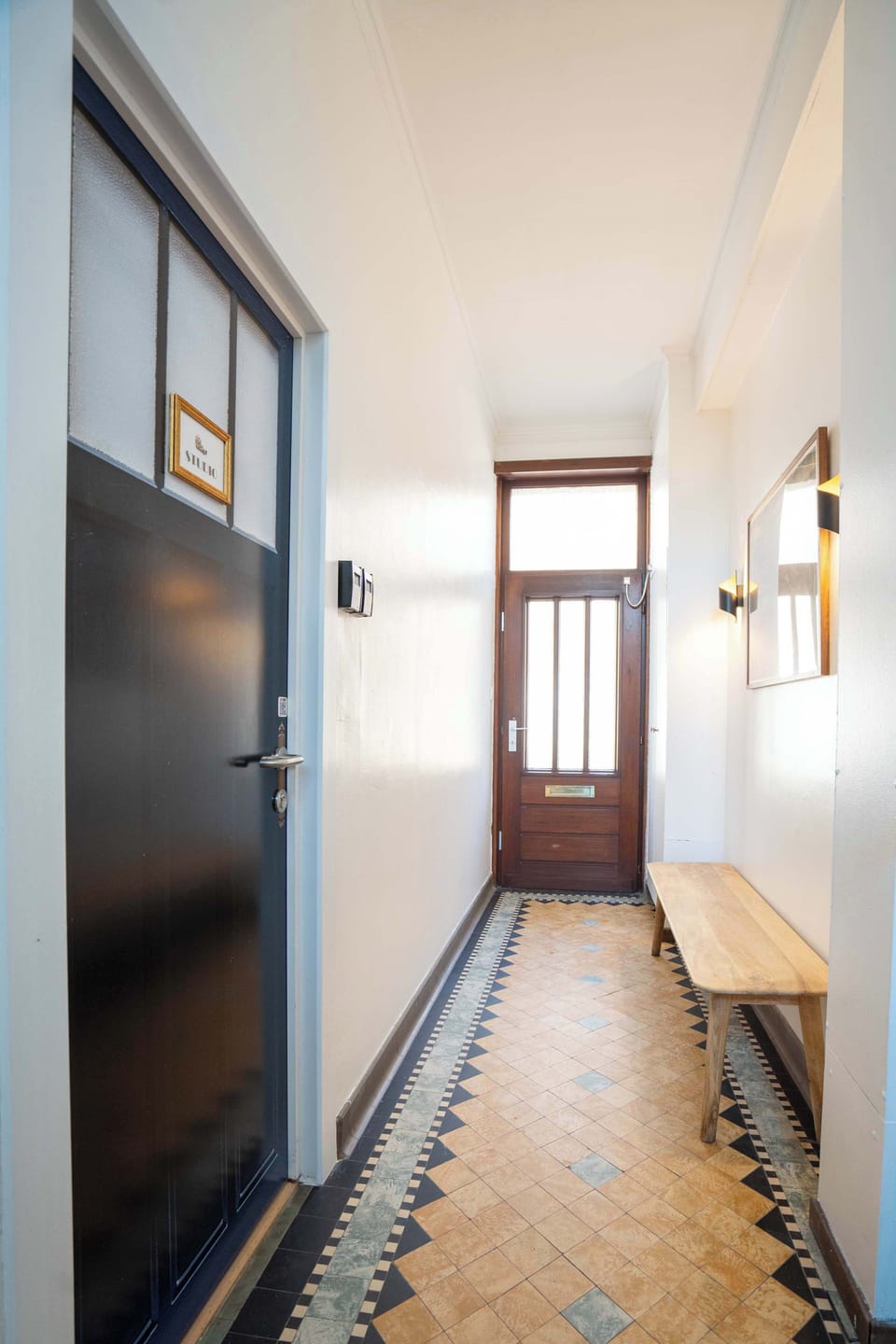 Vintage hallway with mosaic tiles and warm light.