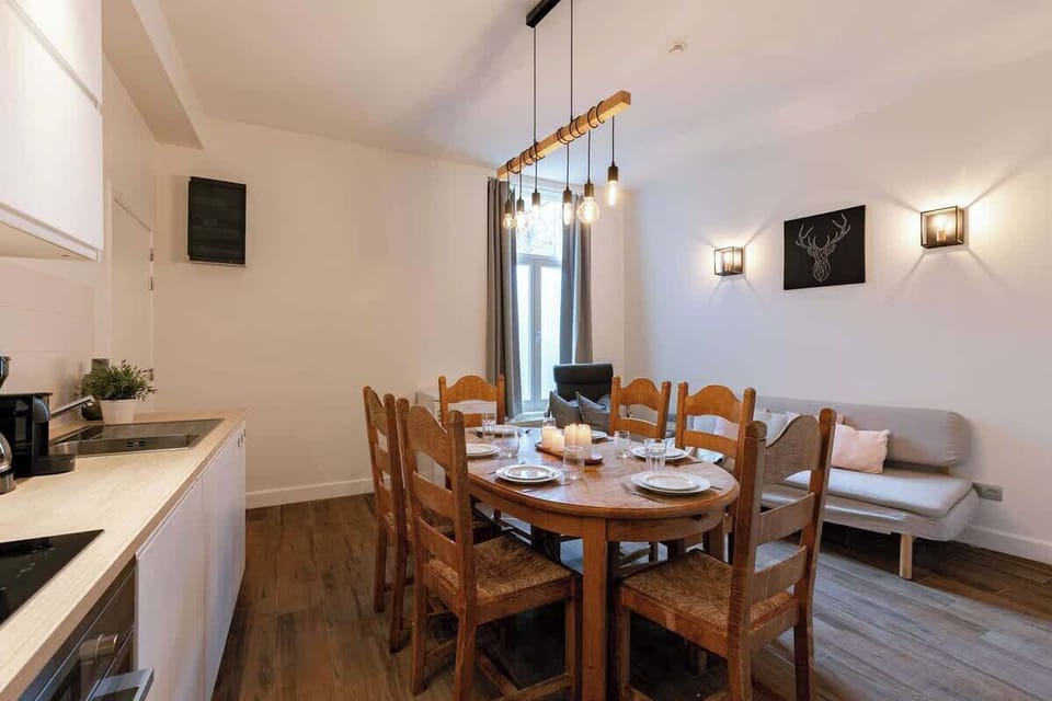 Rustic dining area with a wooden table set for six and soft lighting.