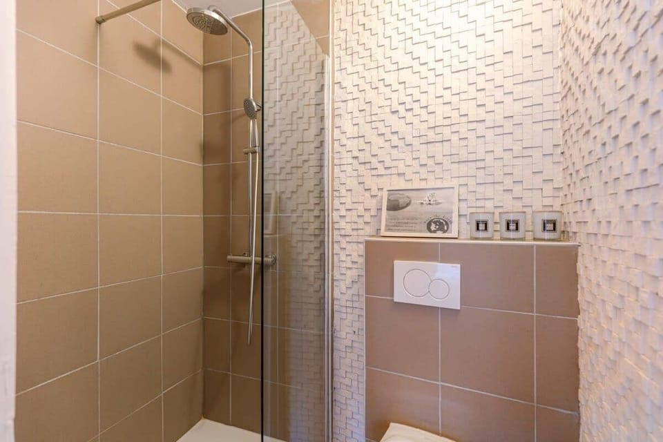 Modern shower area with textured wall tiles and a glass partition
