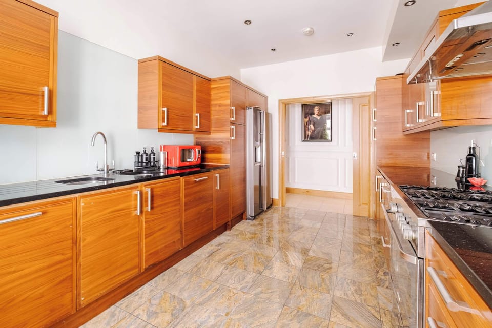 A fully equipped kitchen with a double door fridge freezer, 5 burner gas hob, Nespresso machine with pods, and a full selection of champagne, wine and martini glasses. Includes filtered water, ice dispenser, washing machine, dryer and dishwasher.