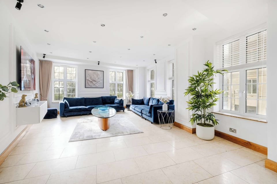 A stunning, oversized living room with breathtaking Hyde Park views, complemented by a grand dining table seating 12 guests. Unwind with a premium 77 inch OLED TV and PlayStation 5, perfect for entertainment, gatherings, and unforgettable stays.
