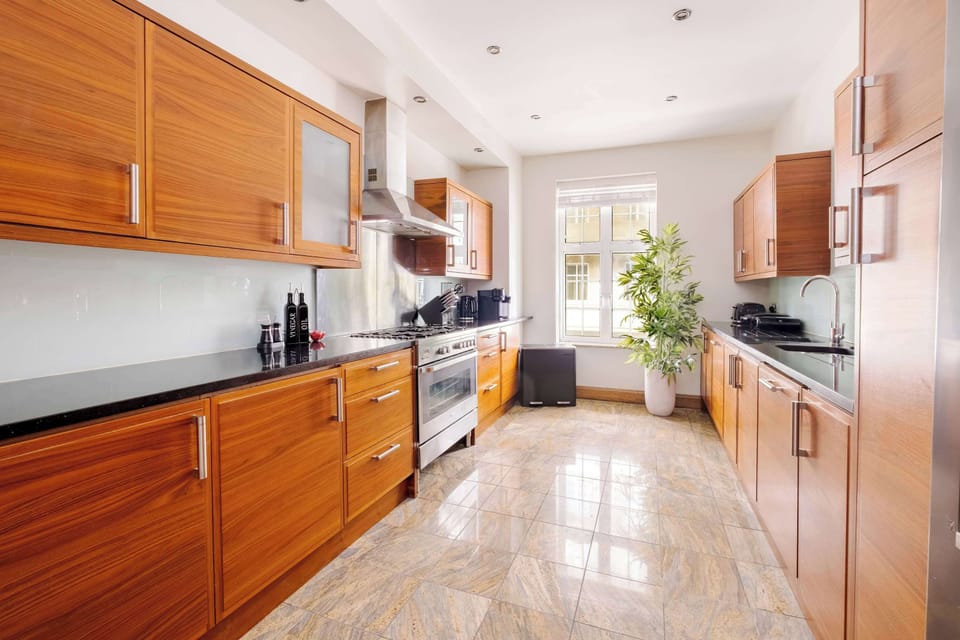 A fully equipped kitchen with a double door fridge freezer, 5 burner gas hob, Nespresso machine with pods, and a full selection of champagne, wine and martini glasses. Includes filtered water, ice dispenser, washing machine, dryer and dishwasher.