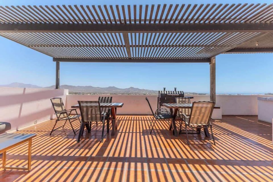 Shared terrace w/ dining table & shade, ideal for breezy outdoor meals