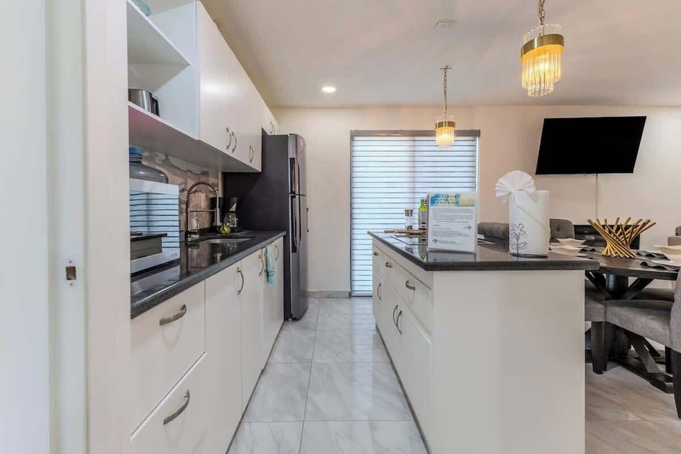 Modern kitchen w/ sleek counters, bar seating & open design