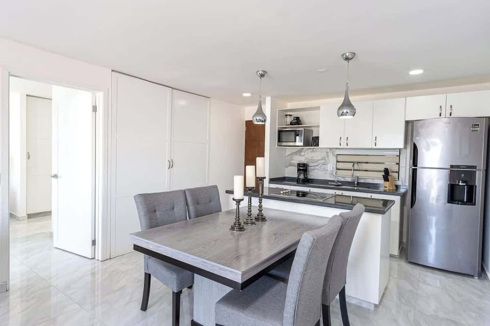 Dining area w/ table seating beside a modern kitchen, ideal for easy shared meals
