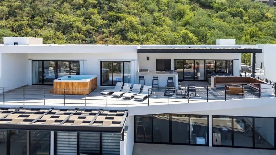 Large outdoor terrace w/ multiple seating zones & hillside backdrop