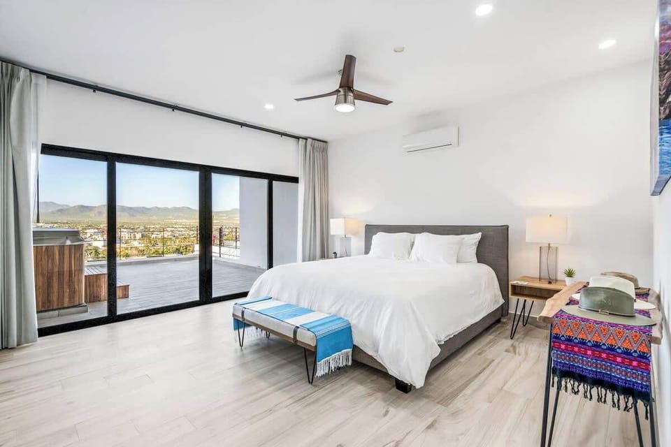 Airy bedroom w/ large windows, soft linens & balcony access for morning light