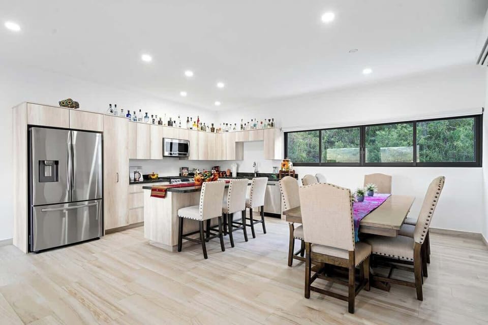 Dining area w/ long table & open flow into the kitchen for shared meals
