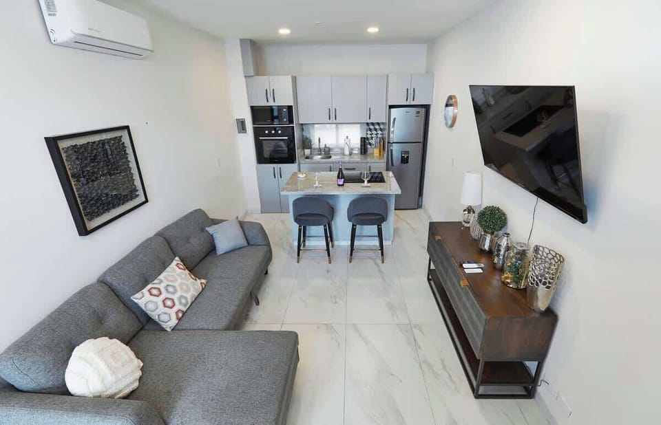 Open living space w/ sofa, TV & easy flow into dining area
