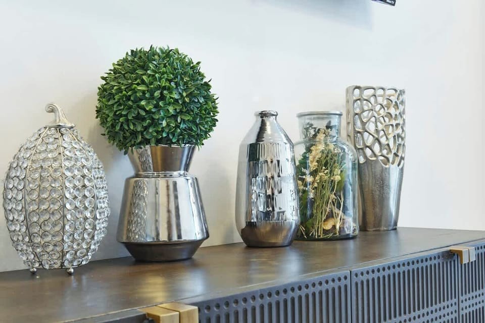 Decorative shelf w/ vases & greenery adding a stylish touch