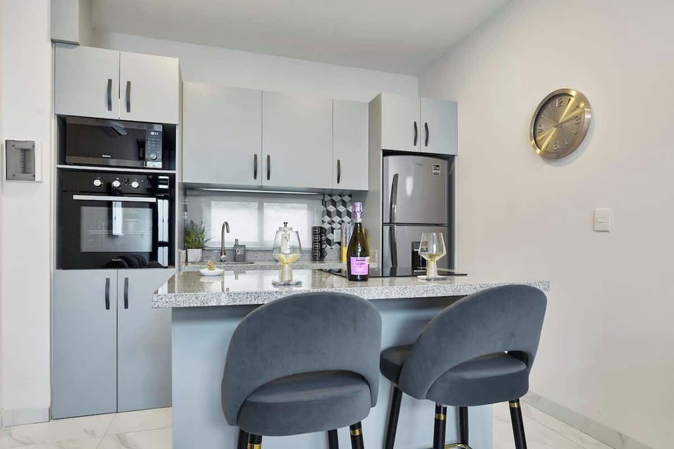 Sleek kitchen w/ bar seating, stainless appliances & open layout
