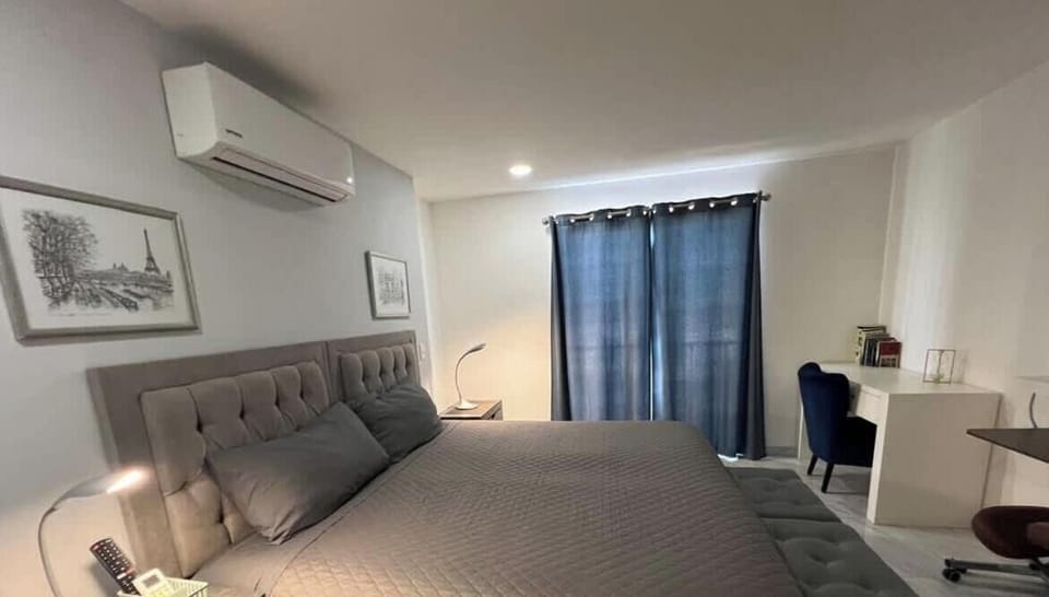 Bright bedroom w/ bed, wall art & window bringing in natural light