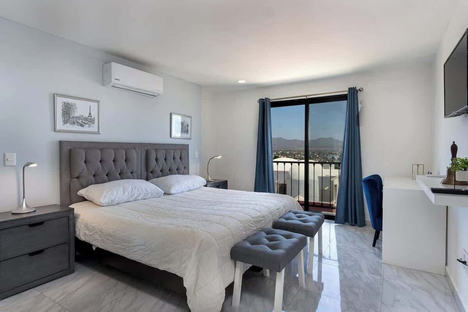 Bright bedroom w/ large windows, a comfy bed & a clean, modern feel