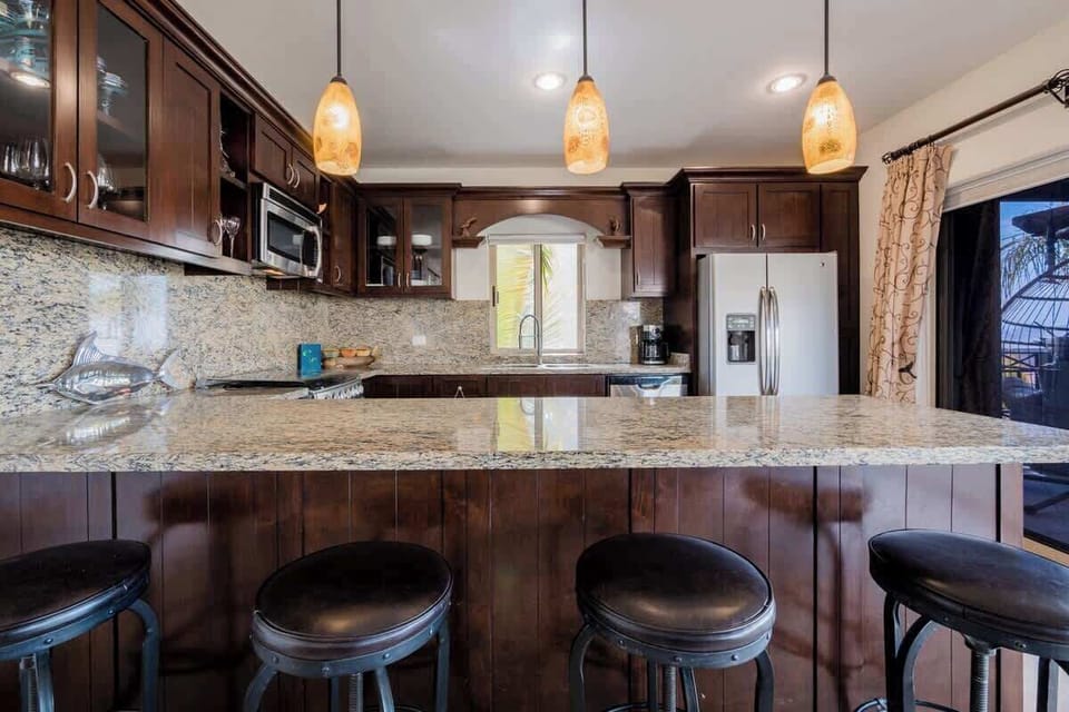 Spacious kitchen w/ bar seating & pendant lighting for casual meals