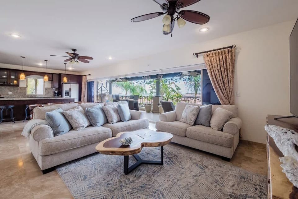 Bright living room w/ plush seating & large windows opening to outdoor views