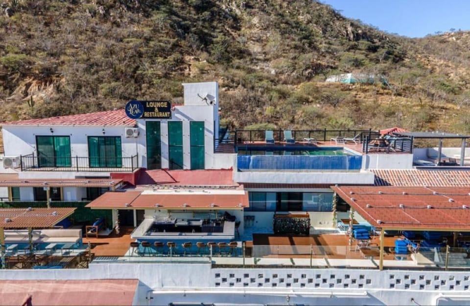 Stylish building exterior w/ pool terrace and hillside backdrop for a scenic setting
