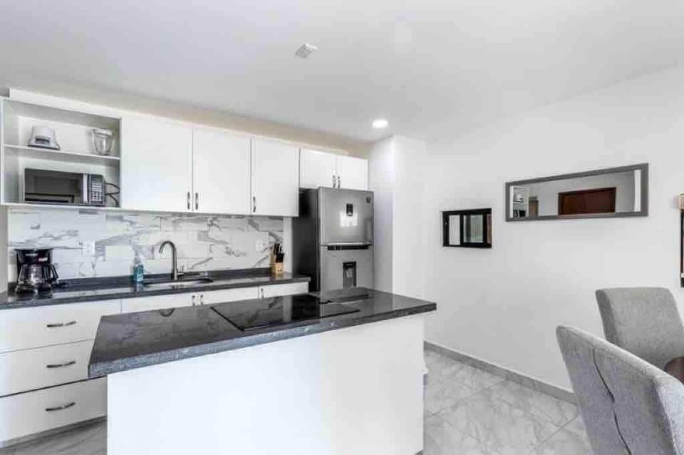Modern kitchen w/ marble backsplash, stainless fridge & ample counter space