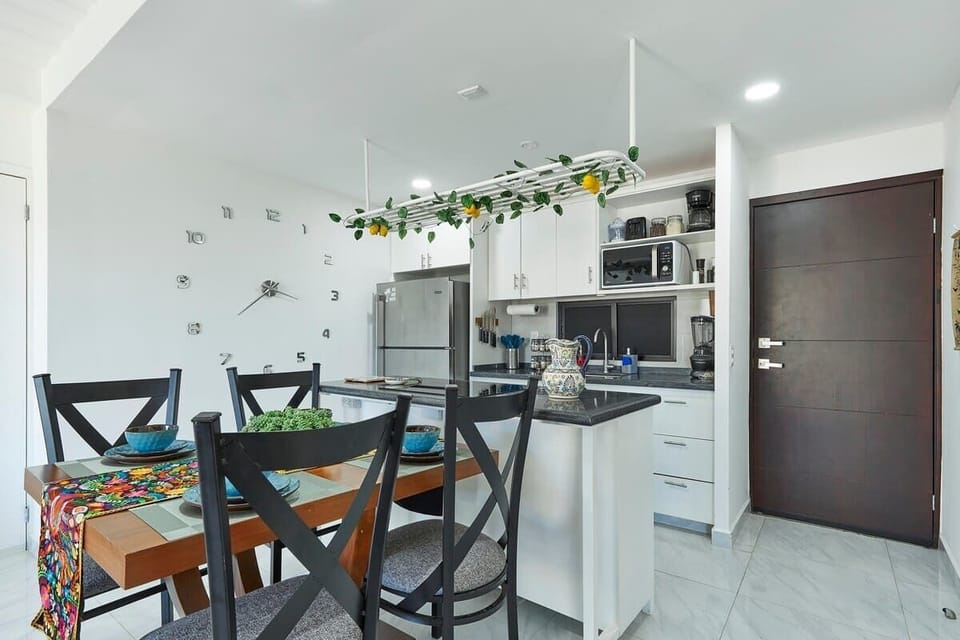 Open kitchen w/ breakfast bar, sleek cabinetry, and dining space just steps away