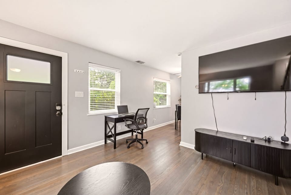 Bright living space with work desk and large smart TV all flowing beautifully.