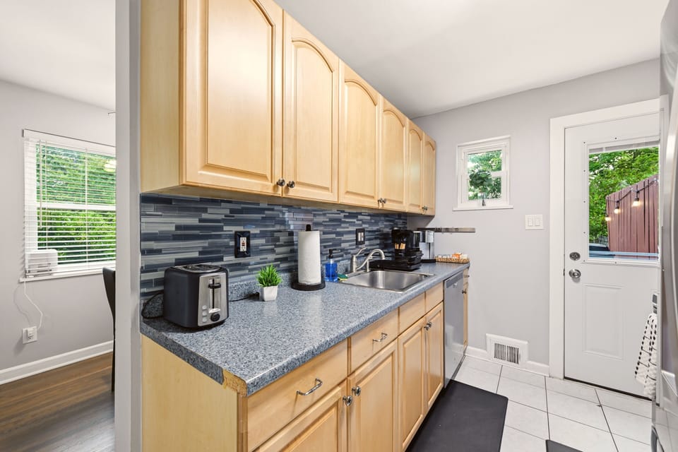 Bright and functional kitchen with warm wood cabinets - back door leads to deck.