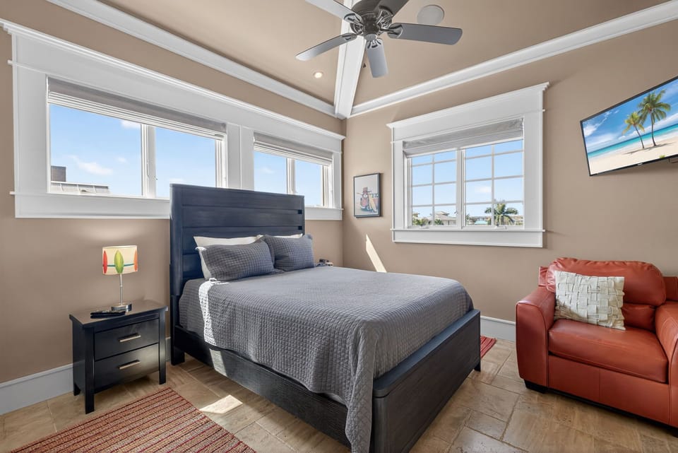 Comfortable queen bed guest room with flat screen tv. Features plenty of windows with room darkening window coverings.