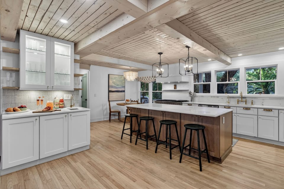 Warm modern kitchen with a spacious island, wood accents, and bright natural light.