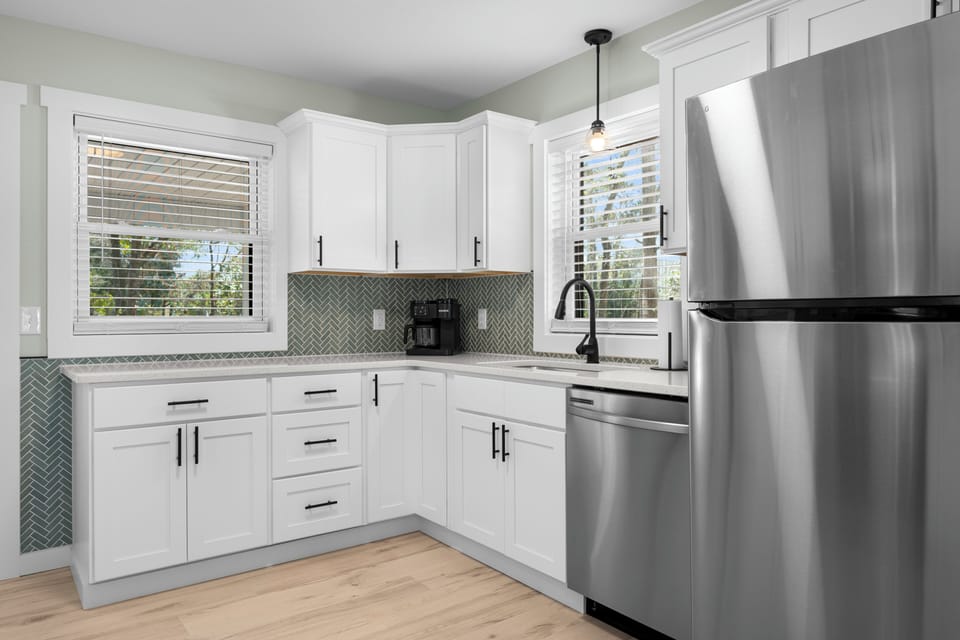 Cook your favorite meals in this bright, modern kitchen with stainless steel appliances and charming herringbone backsplash.