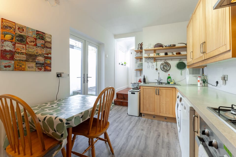 A fully equipped kitchen features a washing machine, dishwasher, toaster, kettle, microwave, and a dining table for shared meals