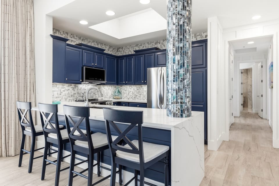 Your gourmet kitchen features navy cabinets, marble counters, and a stylish breakfast bar where you'll start each morning.