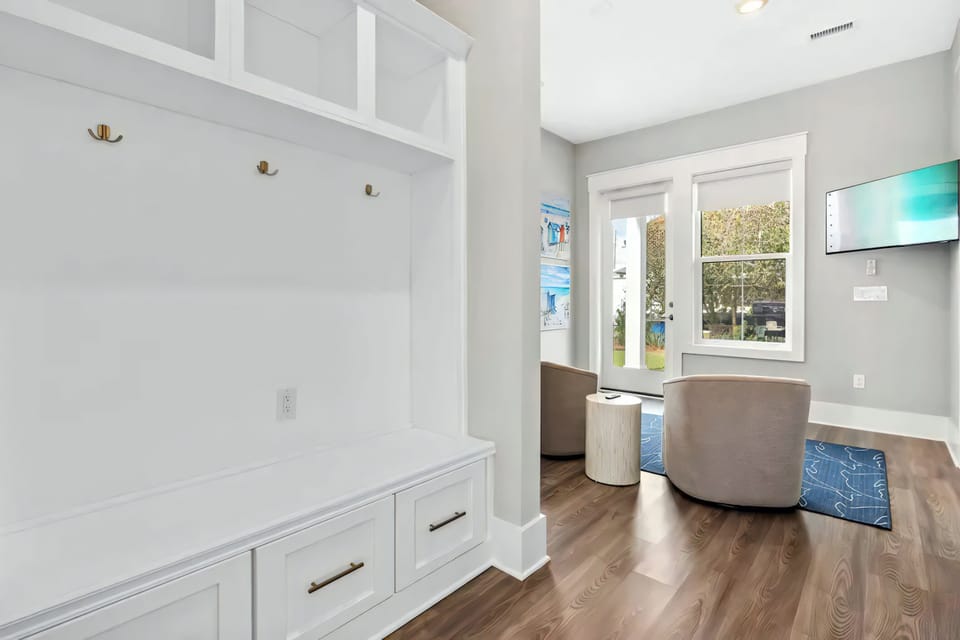 Custom built-in cabinetry and brass hooks create a refined space for keeping essentials organized.