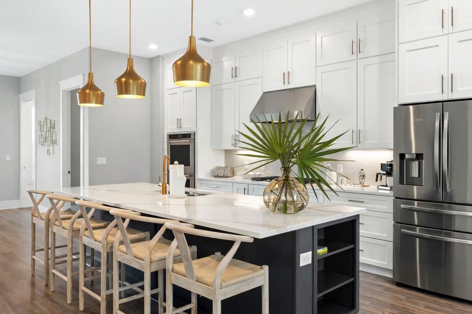 Elegant white cabinetry and a generous island create the heart of the home.